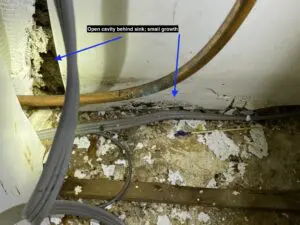 A picture of the inside of a room with pipes and wires.