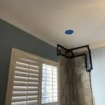A blue ceiling fan in the corner of a room.