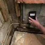 A person is checking the water level in an old house.