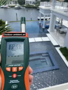 A person holding up an outdoor ambient air meter.
