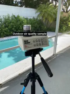 A camera on top of a tripod with water in the background.