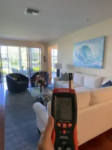 A person holding up a remote control in front of a living room.