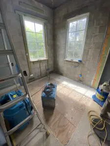 A room with many windows and tools on the floor.
