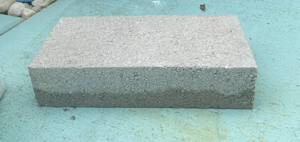 A close up of the bottom edge of a concrete block.