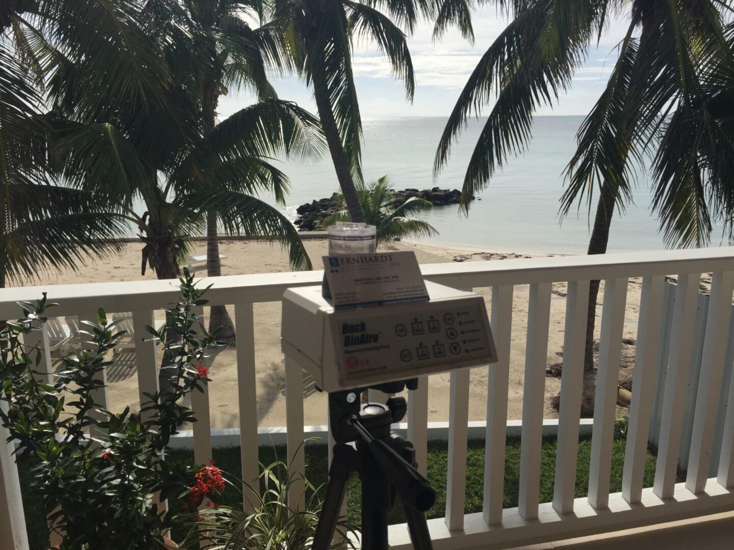 A camera on top of a tripod in front of the ocean.